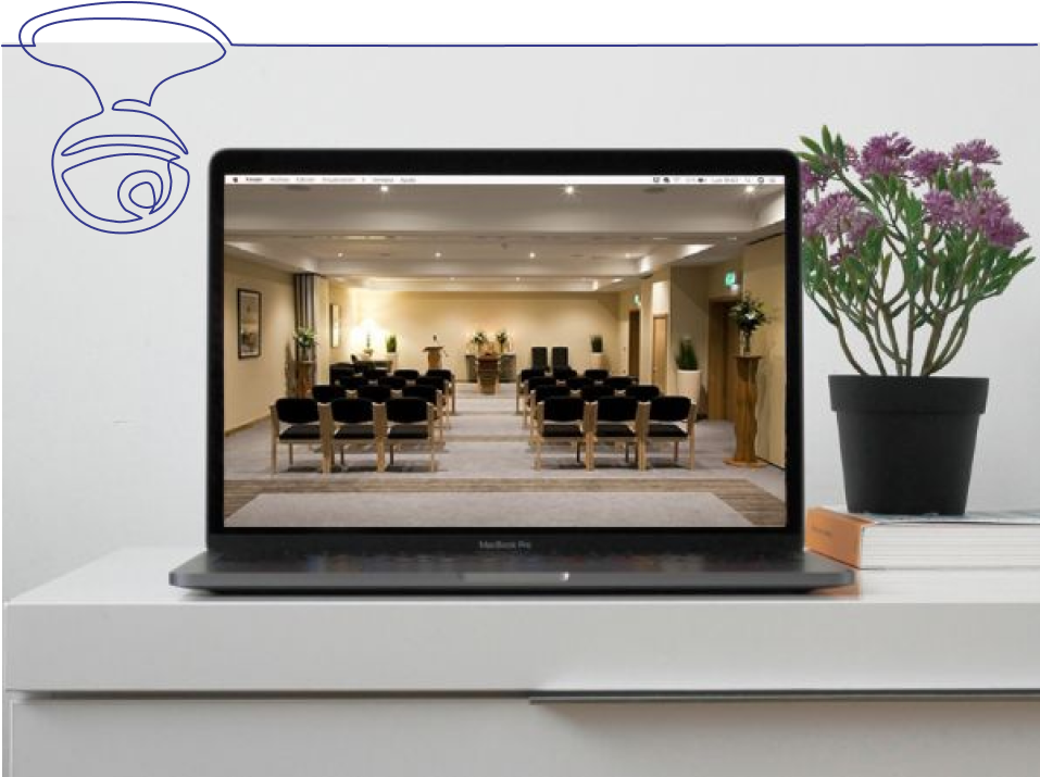 Funeral service live stream on a laptop displayed on desk with flowers and books 