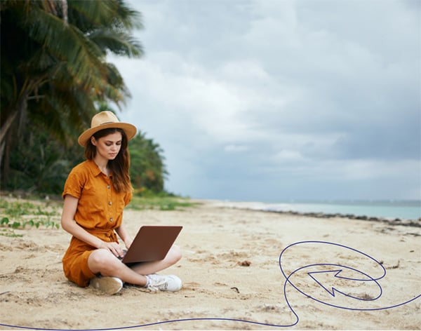 A person wearing a hat on the beach watching a funeral service recording on a laptop